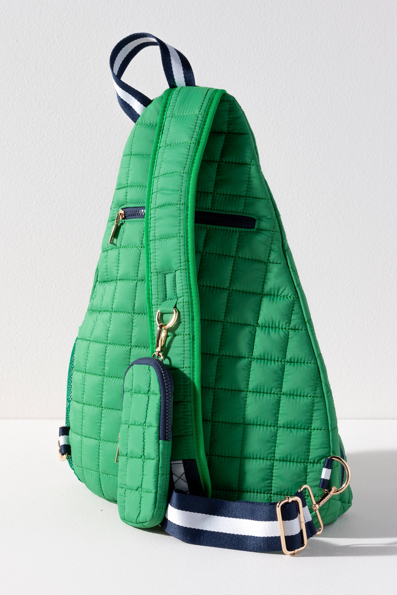 Kelly green quilted nylon tennis and pickleball sling backpack with navy zippers and navy white striped strap