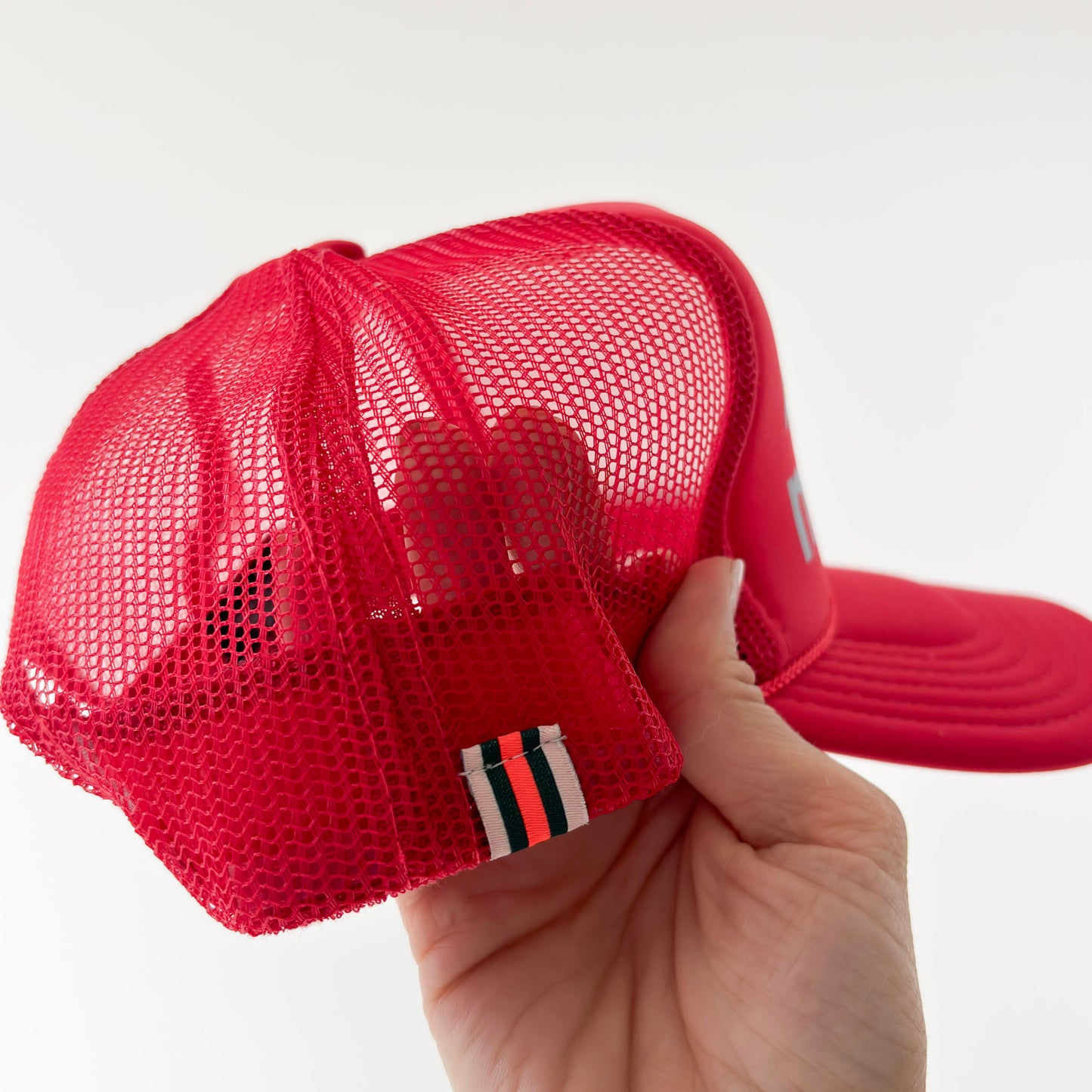 Women's bright red foam mid profile snap back trucker hat with blue bikinis & martinis. graphic