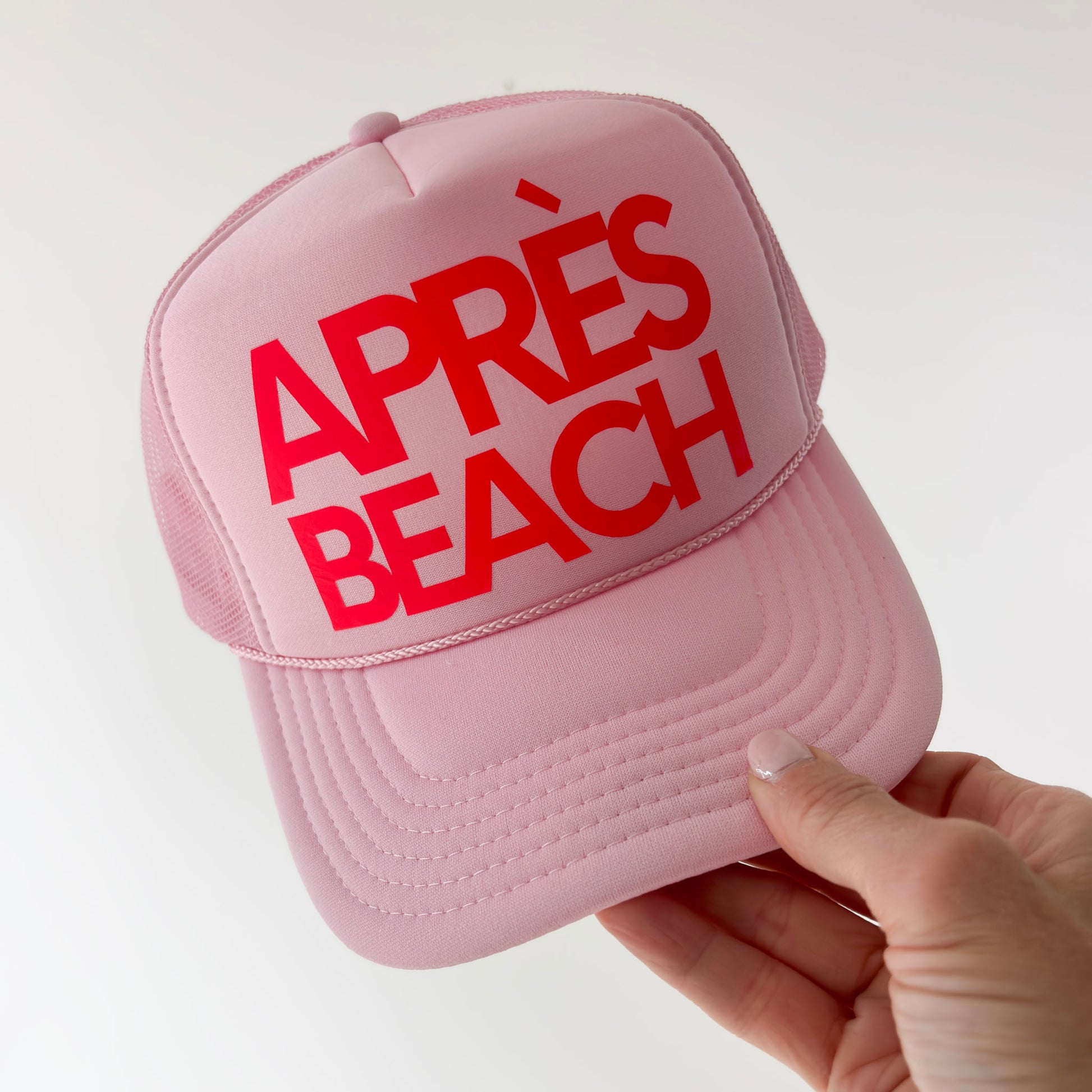 Women's light pink high profile trucker hat with neon coral après beach print