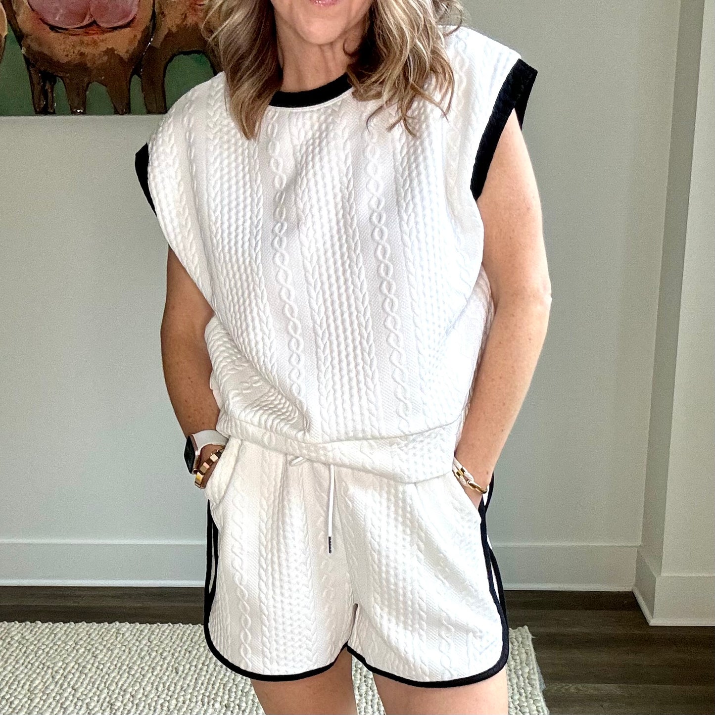 White cable knit textured pull on knit short with black tipping at curved hem.  Side pockets.