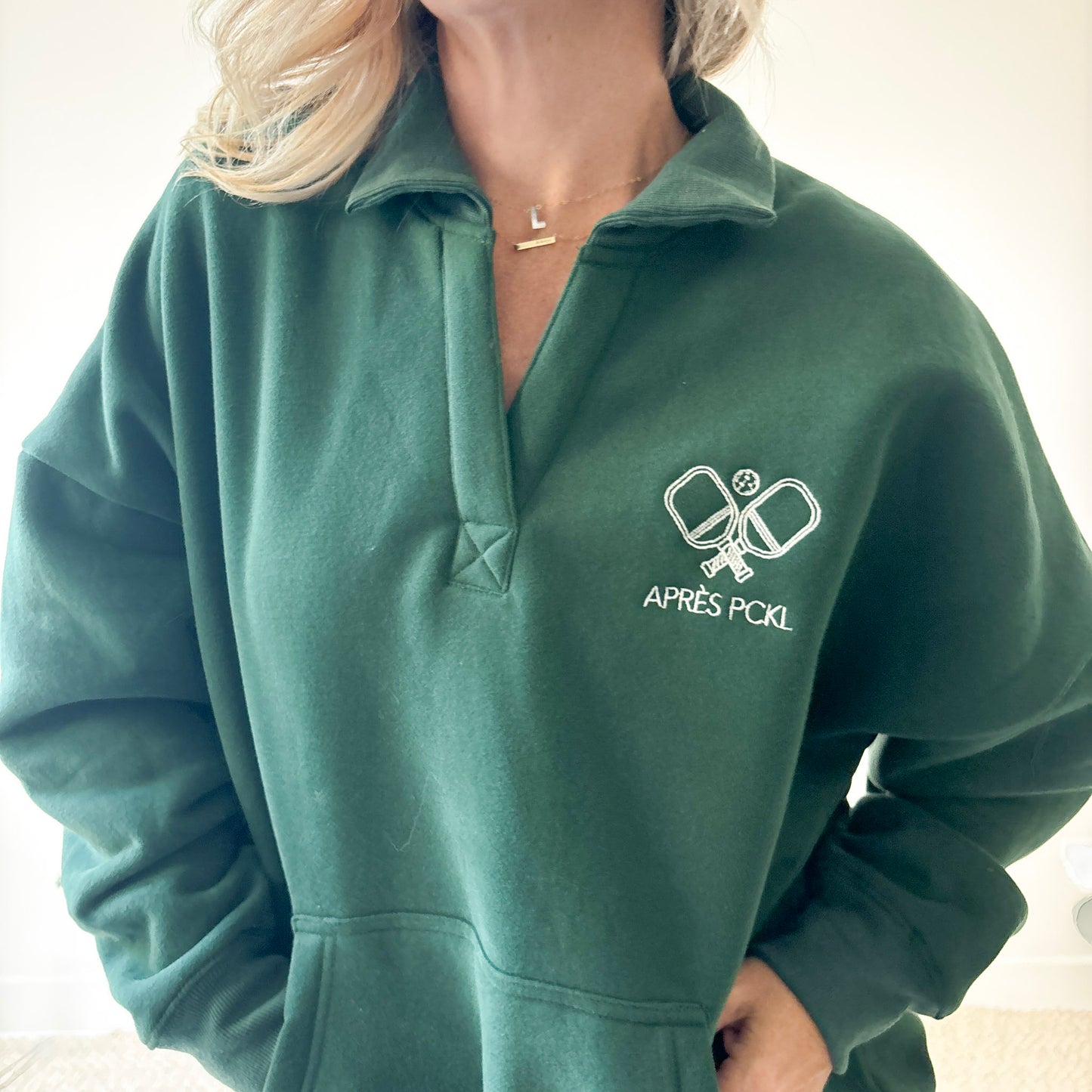 Dark green oversized collared sweatshirt with après pckl pickleball paddle embroidery