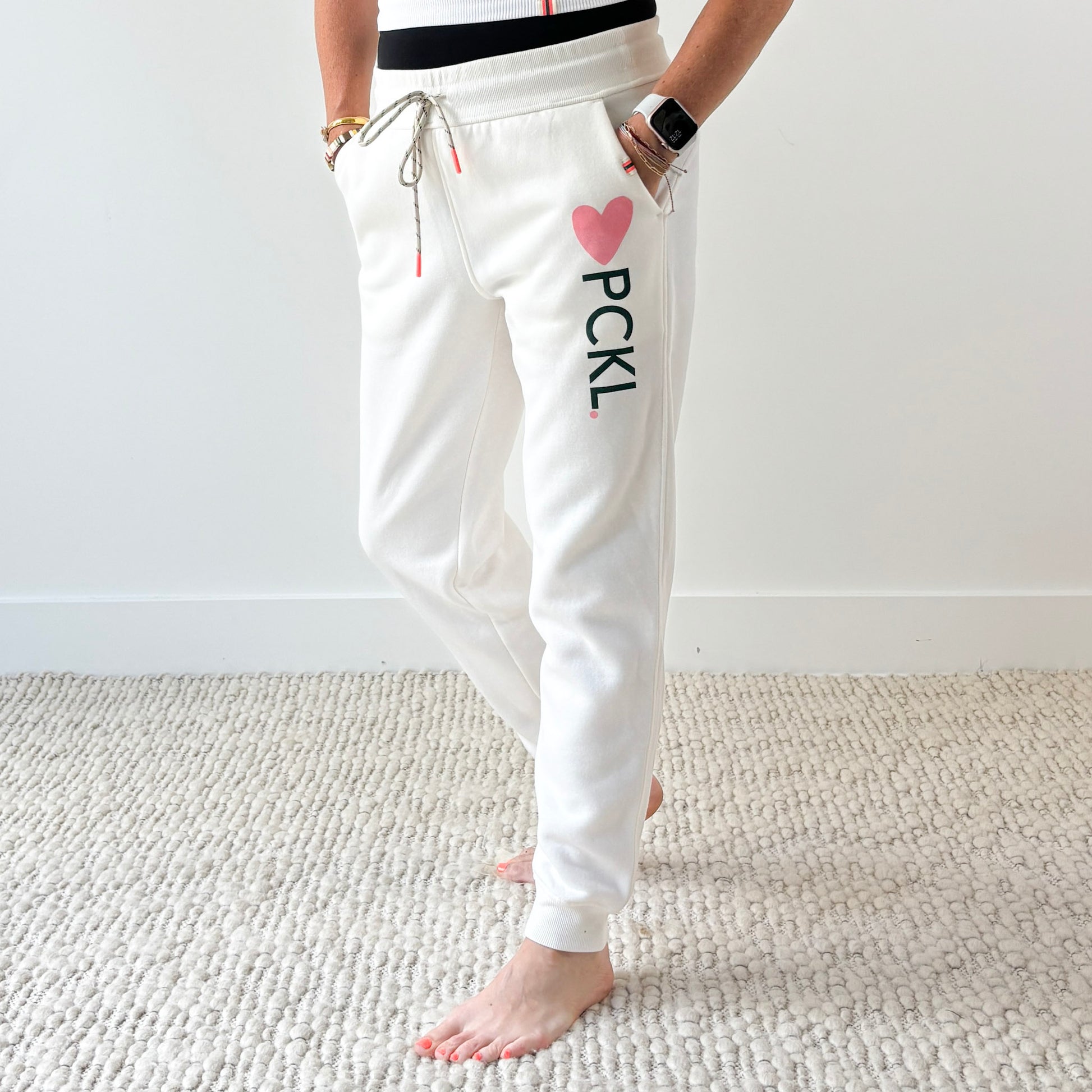 Women's ivory slim fit fleece jogger with pink heart and dark green pckl pickleball print.