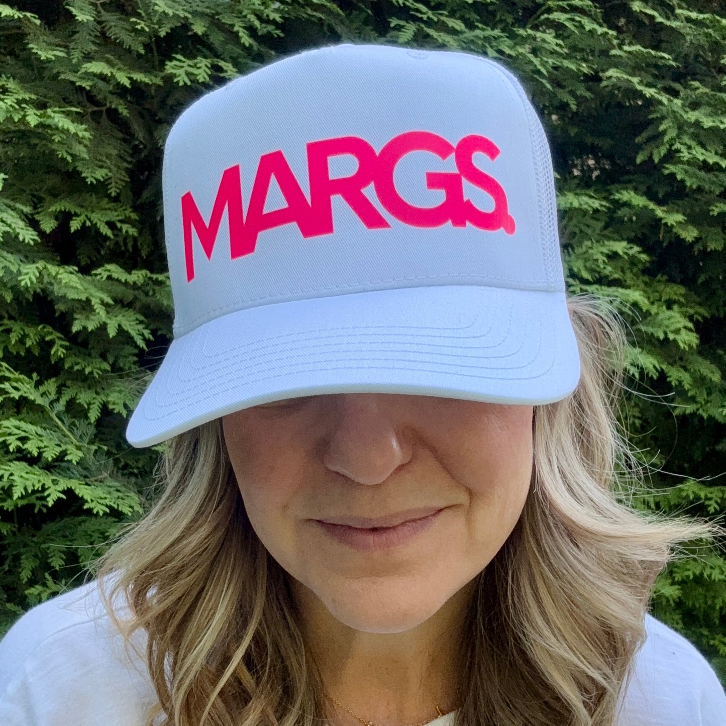 Women's white high profile trucker hat with neon coral margs. print graphic
