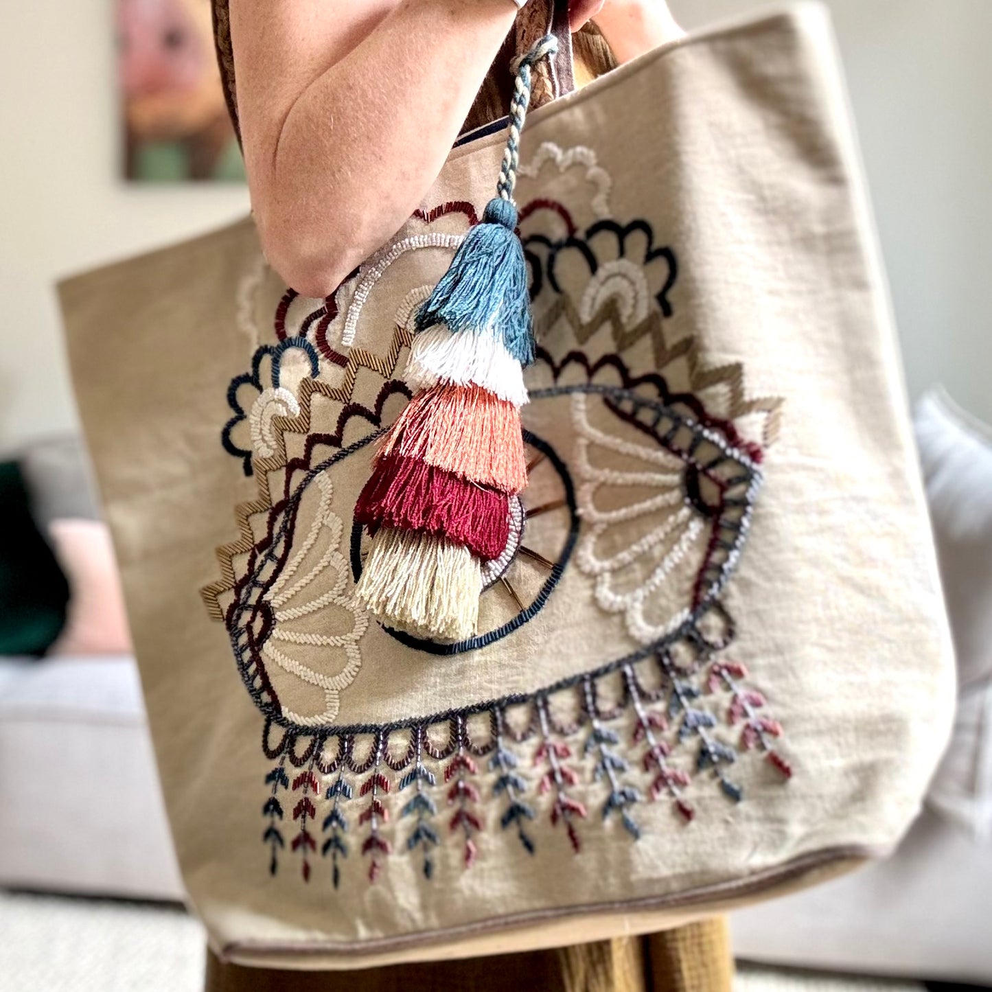 Tan heavy canvas tote shoulder bag with braided strap and hand beaded evil eye embroidery and multi color tassel