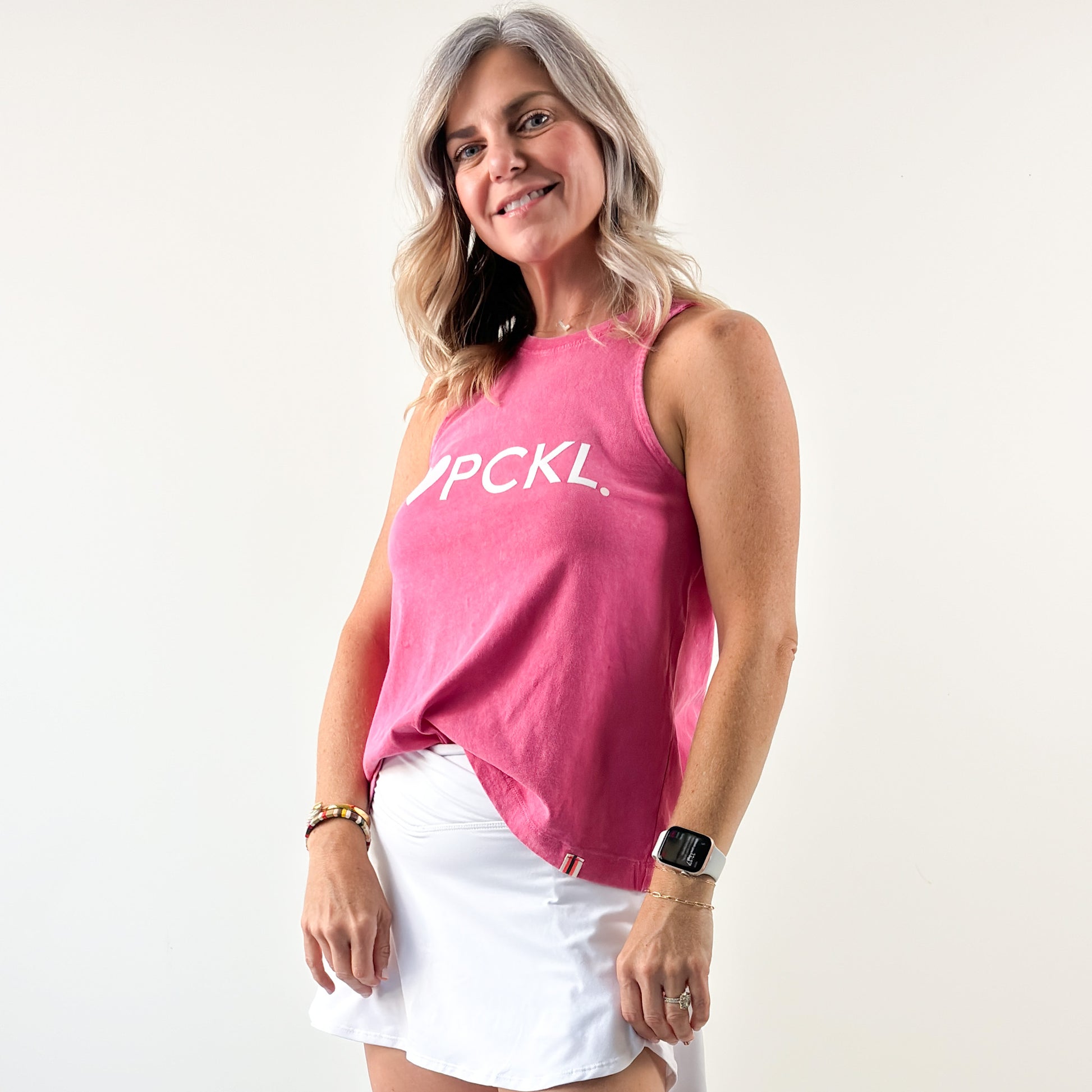 Women's bright pink swing fit racerback pickleball tank top with light pink heart and ivory pckl graphic